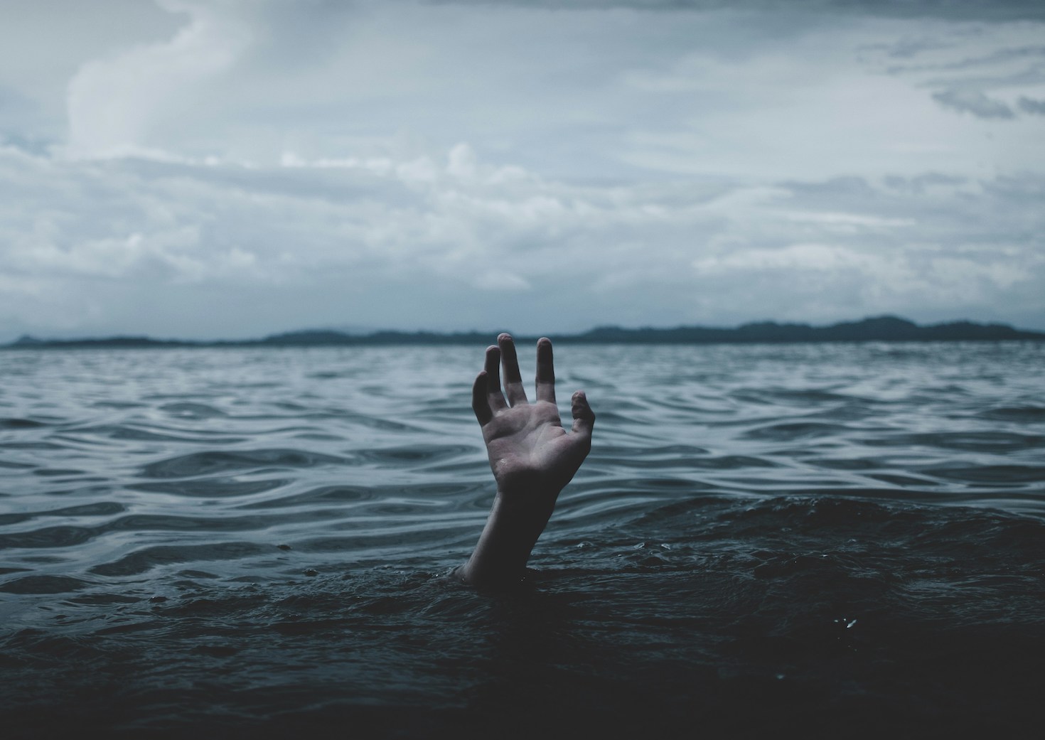 A hand reaching up from deep water.