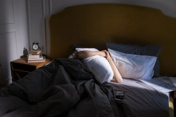 Fatigue, trauma, or chronic stress can all make mornings feel unbearable. This image speaks to the quiet struggle behind staying under the covers.